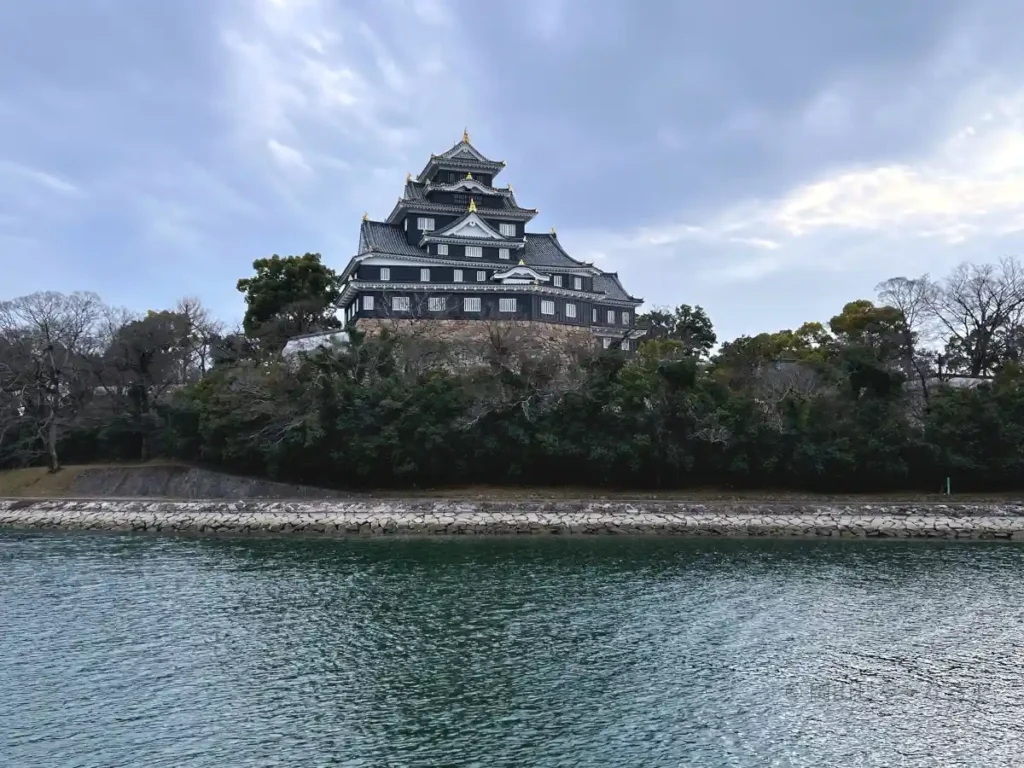 後楽園南門そばの河川敷から見上げる岡山城。水面に浮かぶように見える撮影スポット