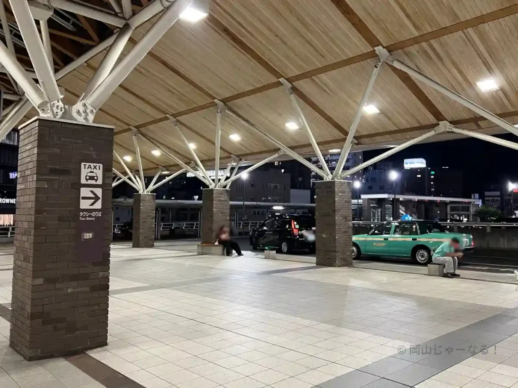 夜21時過ぎの岡山駅西口タクシー乗り場。屋根の照明が多く、床面まで明るく照らされており、東口よりも明るく感じられる様子が写っている