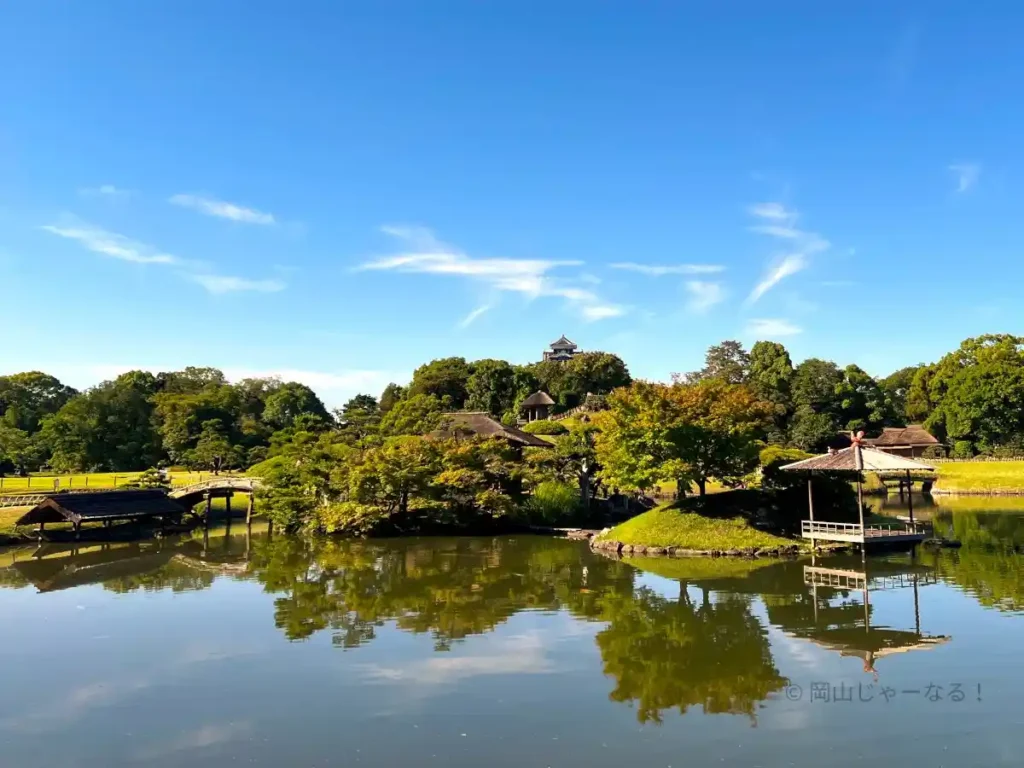 沢の池の水面に映る緑と青空の写真