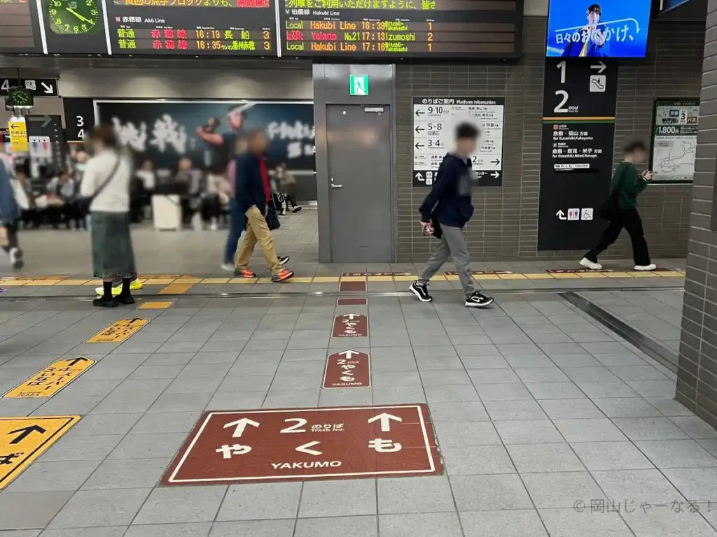 「2のりば やくも」の案内が表示された床。ホームの方向を記した茶色の矢印。